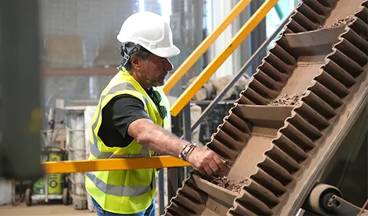 Feed olive wood into the reactor via a belt conveyor